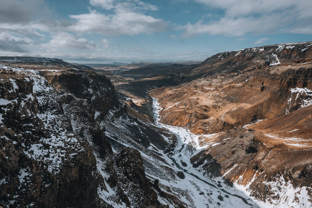 Aerial drone view of Haifoss waterfall in Iceland during Winter in the Highlands. Blue sky and clouds in snow. - Valokuva, kuva