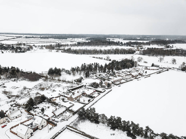 Aerial view of a small village in the British countryside during a rare heavy snowfall known as the beast from the east - Foto, Bild