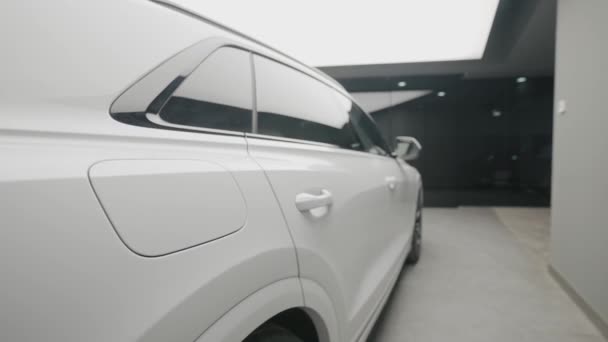 Sivunäkymä uuden valkoisen auton varastossa. Toimintaa. Kaunis ulkonäkö uuden valkoisen auton myyntisalongissa. Tyylikäs pitkä auto myytävänä - Materiaali, video