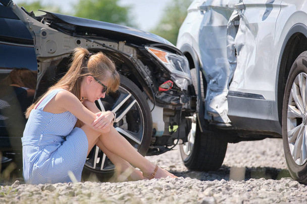 Напряженная женщина-водитель, сидящая на улице, шокирована после автомобильной аварии. Концепция безопасности дорожного движения - Фото, изображение
