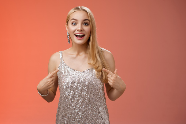 Surprised wondered happy blond charming cheerful woman in glittering silver dress pointing herself amused thrilled picked be chosen participate awesome event, standing joyful red background - Photo, Image