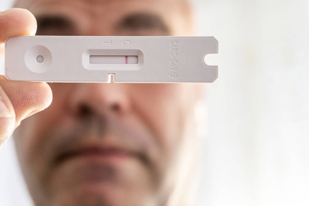 Persona irreconocible muestra un primer plano de una prueba de antígeno covid negativo - Foto, imagen