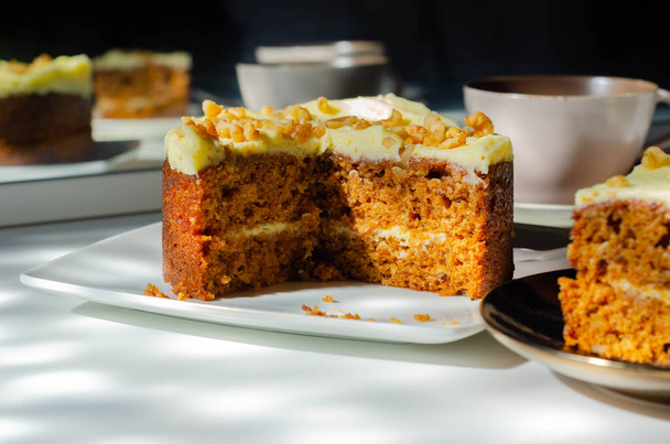 Нарезанный морковный торт, наполненный сливочным кремом из сыра и украшенный грецкими орехами, пекарней
 - Фото, изображение