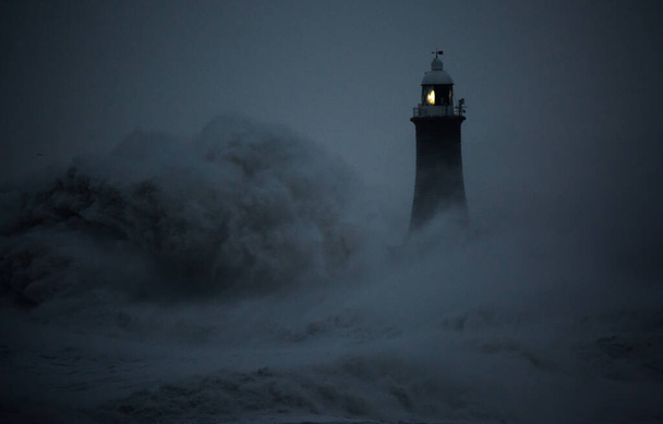 Wiatr burzy z Arwen powoduje ogromne fale uderzające w latarnię morską i północne molo strzegące ujścia Tyne w Tynemouth w Anglii. - Zdjęcie, obraz
