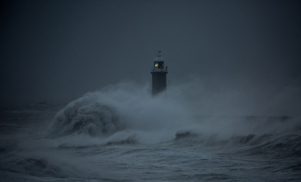 A viharból fúj a szél, és hatalmas hullámok csapnak le a világítótoronyra és az északi mólóra, védve a Tyne torkolatát Tynemouth-ban, Angliában. - Fotó, kép