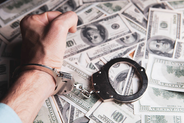 handcuffed at the table with money - Φωτογραφία, εικόνα