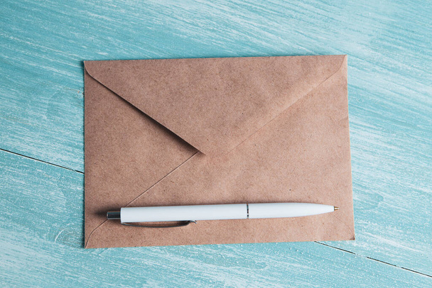 an envelope for letters and a pen on the table - Fotó, kép