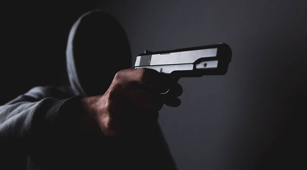 masked man holding a gun - Foto, afbeelding