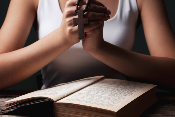 woman praying on book holding cross - Photo, Image