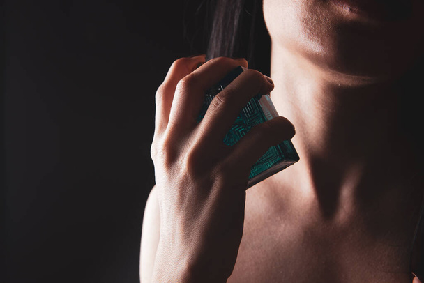 woman sprinkles perfume on her neck - Photo, Image