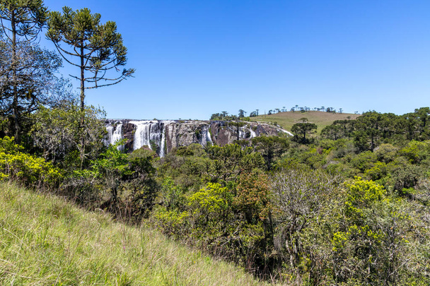 ブラジルのリオグランデ・ド・スル州の周りのフィールドと森を持つ滝 - 写真・画像