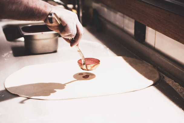 A pizzaséf szószt tett a bázis egy kereskedelmi konyhában - Fotó, kép