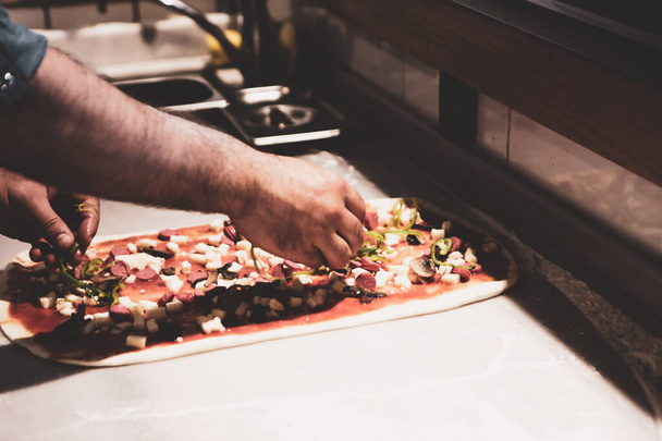 pizza kokki laittaa kastike pohja kaupallisessa keittiössä - Valokuva, kuva