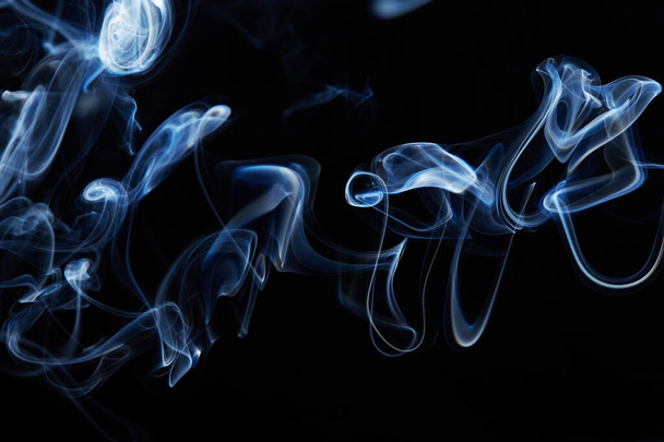 blue smoke on black background with abstract blur motion wave swirl . Wisp of Smoke. Cigarette smoke waves and clouds  texture - 写真・画像