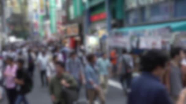 Defocused shot van de menigte van mensen lopen in de straat in Tokyo Akihabara gebied, bekend om elektronische en anime winkels in Japan. Aziatische voetgangers winkelen in Japanse winkels. Wazige achtergrond - Video