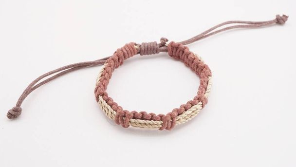 An isolated ethnic bracelet on white background. The bracelet is made off the various rope - Photo, Image
