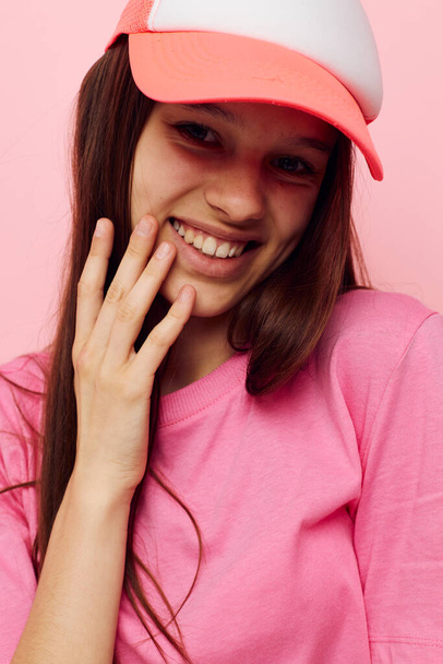 jong meisje in een roze t-shirt met een pet op haar hoofd casual dragen - Foto, afbeelding