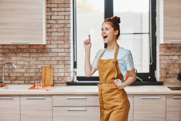 a housewife gestures with his hands kitchen apartment kitchen utensils interior household concept - Fotografie, Obrázek
