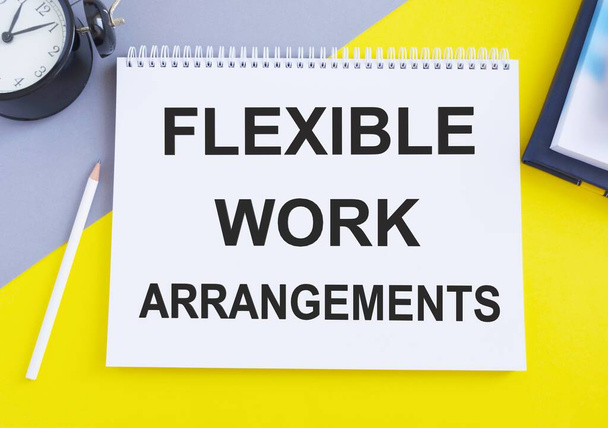Flexible Work Arrangements. text on white notepad on gray, yellow background, Top view flat lay, business concept - Fotó, kép