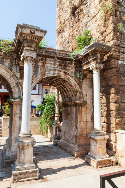 Antalya, turkey - 09. 01. 2021: Column and arch of a famous tourist and archaeological site of Antalya is The Emperor Hadrian's gate in the old city. Travel destinations and vacation in Turkey - Фото, изображение