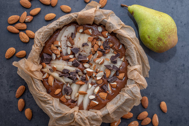 homemade chocolate cake with nuts and almonds on a dark background. top view. - Φωτογραφία, εικόνα