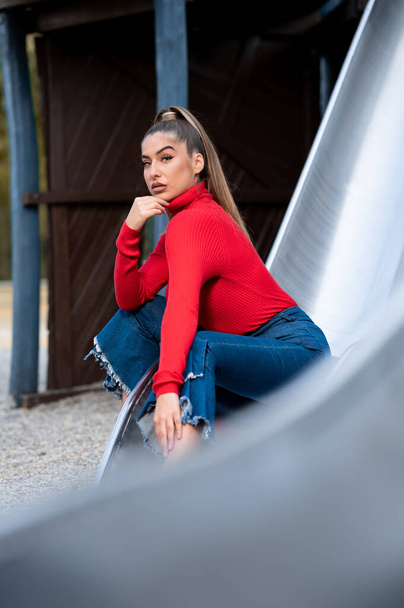 portrait of beautiful young woman in red sweater posing  - Foto, Bild