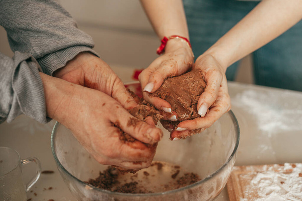 Close up photo of woman man hands, Happy couple baking cookies on cozy kitchen at home, mixing dough, mom and dad in making cookies, teamwork, baking lesson - Foto, immagini