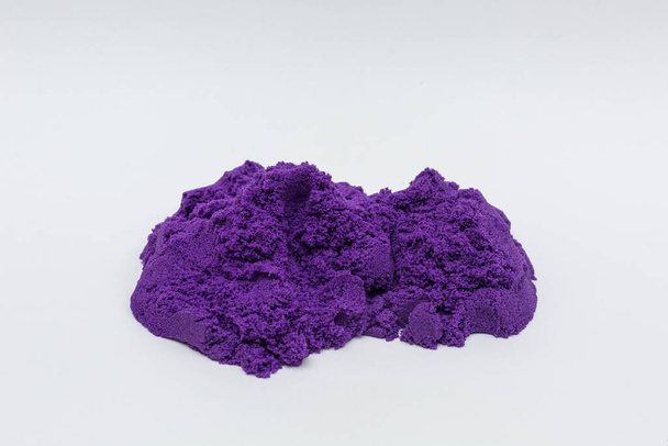 Scattered kinetic sand of purple color on a white background. - Fotografie, Obrázek
