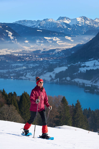   мила і активна старша жінка, яка біжить на снігоступах в Альгау над Імменштадтом (Баварія, Німеччина).                              - Фото, зображення