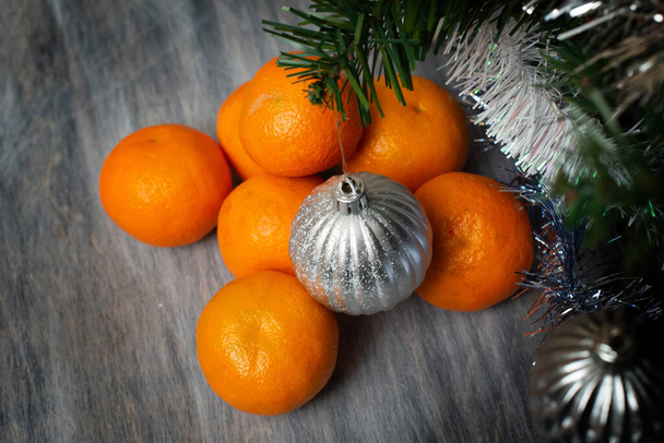 tangerines on the table near the New Year tree - 写真・画像