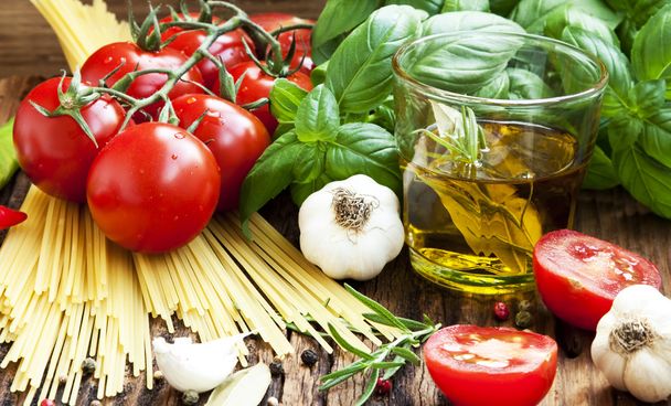 Italiaanse keuken ingrediënten, spaghetti, tomates, olijfolie en bas - Foto, afbeelding