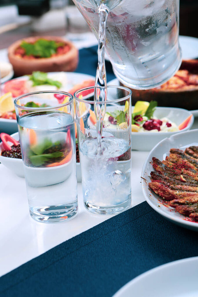 トルコとギリシャの伝統的なダイニングテーブル(特別なアルコールドリンクラキ付)。ウーゾとトルコのラキは、トルコ、ギリシャ、キプロス、レバノンで広く消費されている乾燥したアニス風味の食前炎です - 写真・画像