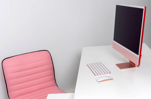 Inglaterra, Reino Unido. 2021. Un escritorio de oficina blanco y una silla rosa, computadora de escritorio y teclado con ratón. - Foto, imagen