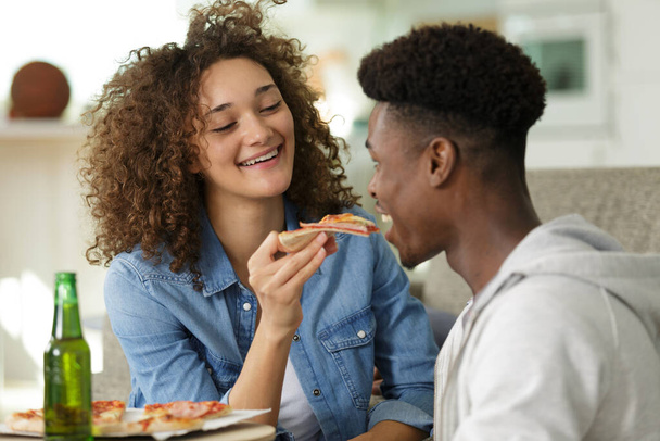 girlfriend feeding pizza to her boyfriend - Photo, Image