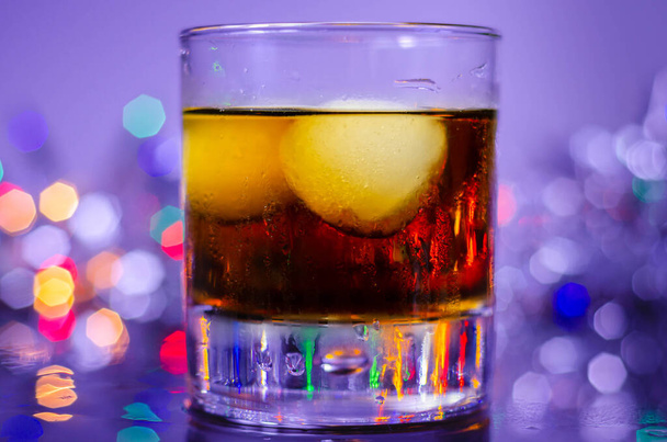 Πιείτε Cuba Libre, ρούμι με κόλα σε ένα παλιό fashoned ποτήρι με δύο μπάλες πάγου, ένα ισχυρό κοκτέιλ - Φωτογραφία, εικόνα