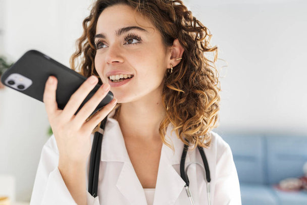 csinos nő orvos, hangüzenetet küld a mobiltelefonjával - Fotó, kép