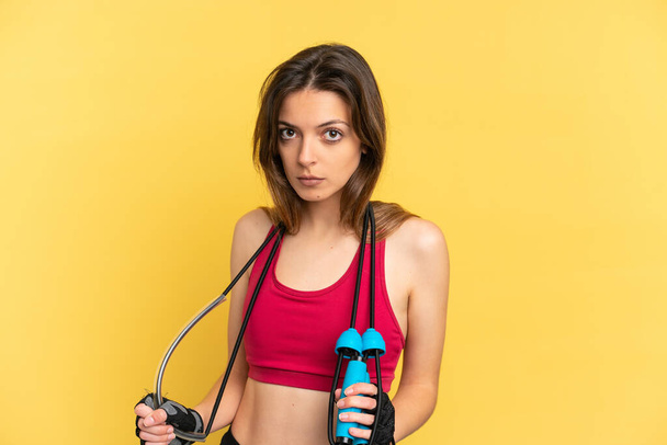 Young caucasian woman isolated on blue background with jumping rope - Photo, Image