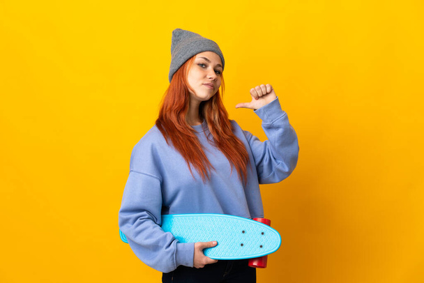 Teenager Russian skater girl isolated on yellow background proud and self-satisfied - Foto, immagini