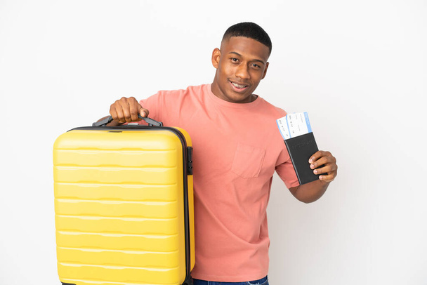 Jovem latino isolado em fundo branco em férias com mala e passaporte - Foto, Imagem