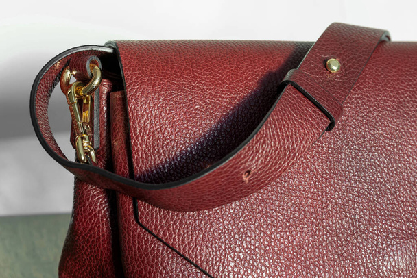 Macro fragment of a maroon leather bag with shoulder strap. Copy space - Foto, Bild