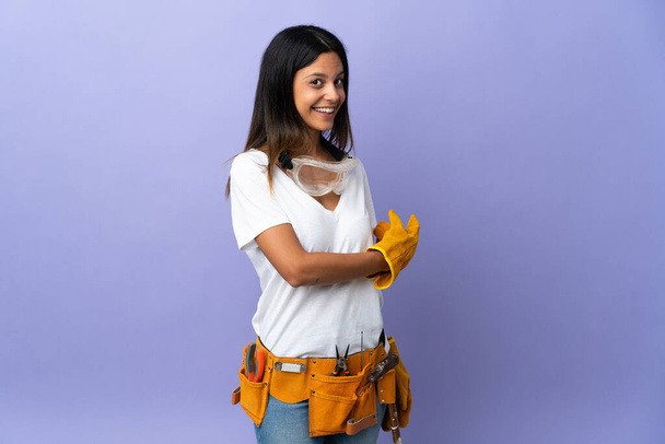 Young electrician woman isolated on purple background pointing back - Foto, Bild
