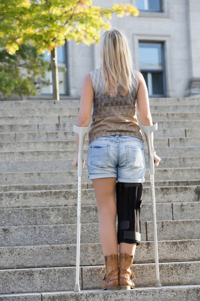 blonde woman with crutches - Φωτογραφία, εικόνα