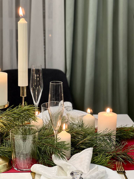 served festive table with candlesticks napkins and Christmas tree - Фото, изображение