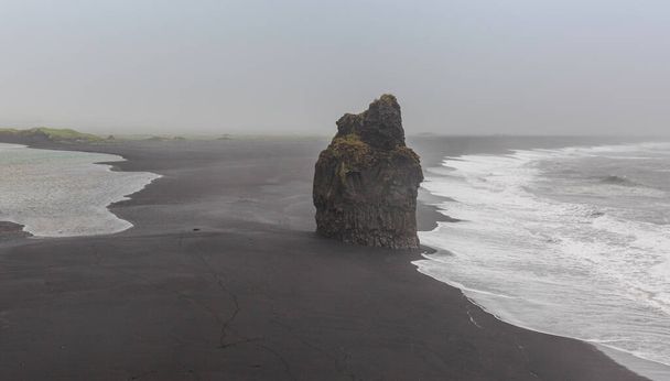 Reynisfjara black sand beach is one of the most iconic landmarks on the south coast of Iceland and as such a major attraction along with the beautiful waterfalls and glaciers in South-Iceland. - Foto, Imagen