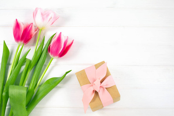 Colorful tulips and gift box on white wooden background. - 写真・画像