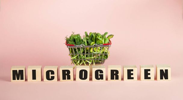Micro greens in a basket on a pink background. Sale of various types of microgreens. Healthy food concept from fresh garden products grown organically. Symbol of health Vitamins from nature. - Photo, image