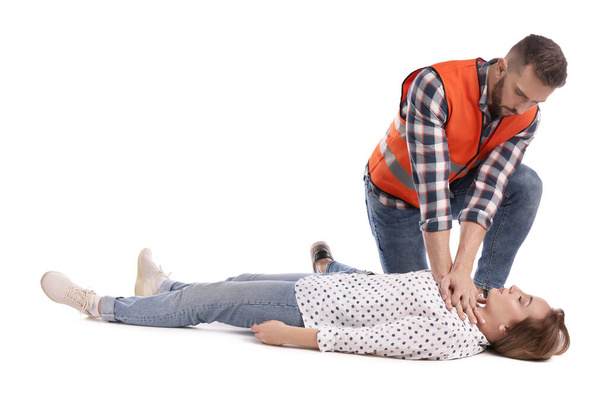 Paramedic in uniform performing first aid on unconscious woman against white background - Foto, afbeelding