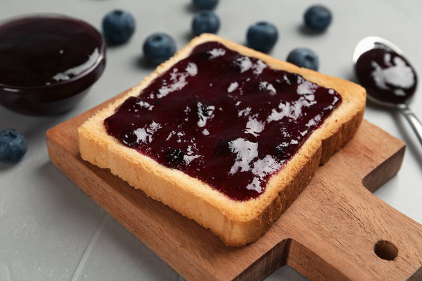 Toast with blueberry jam served on grey table - Foto, afbeelding