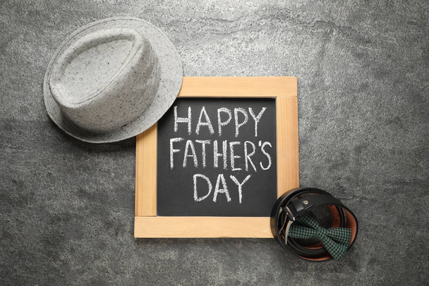 Chalkboard with phrase Happy Father's Day and men accessories on grey background, flat lay - 写真・画像