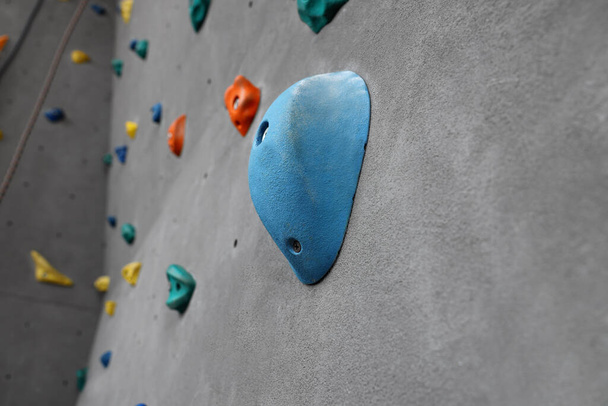 Climbing wall with holds in gym. Extreme sport - Foto, imagen